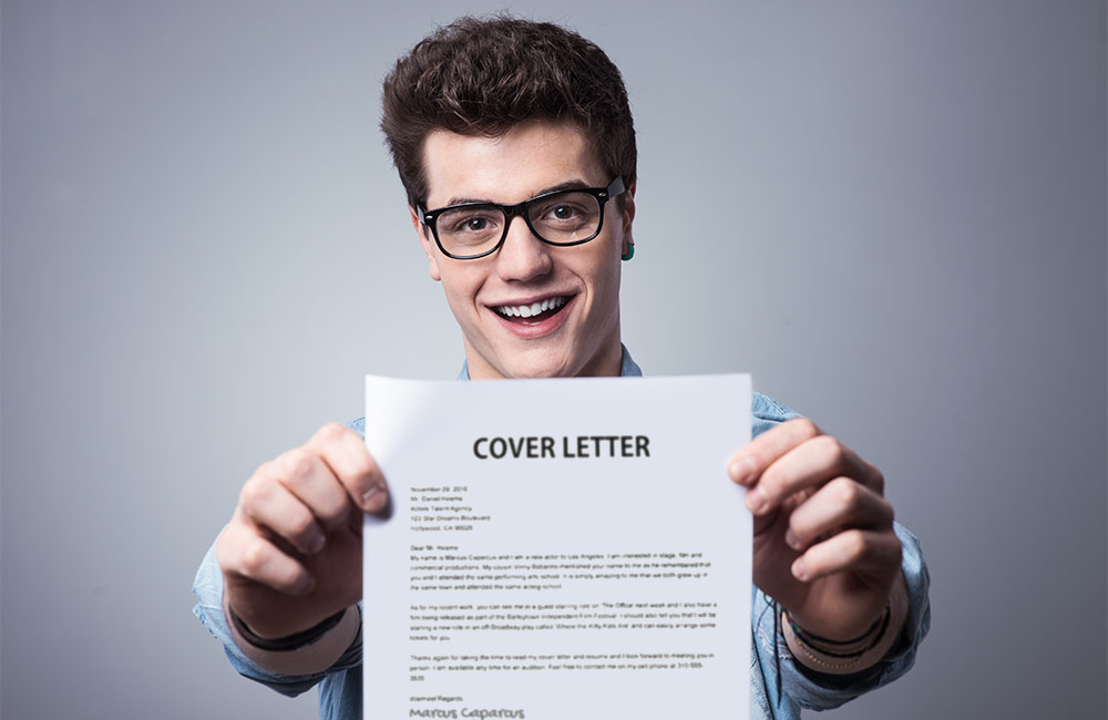 A goofy guy holds his cover letter in front of him