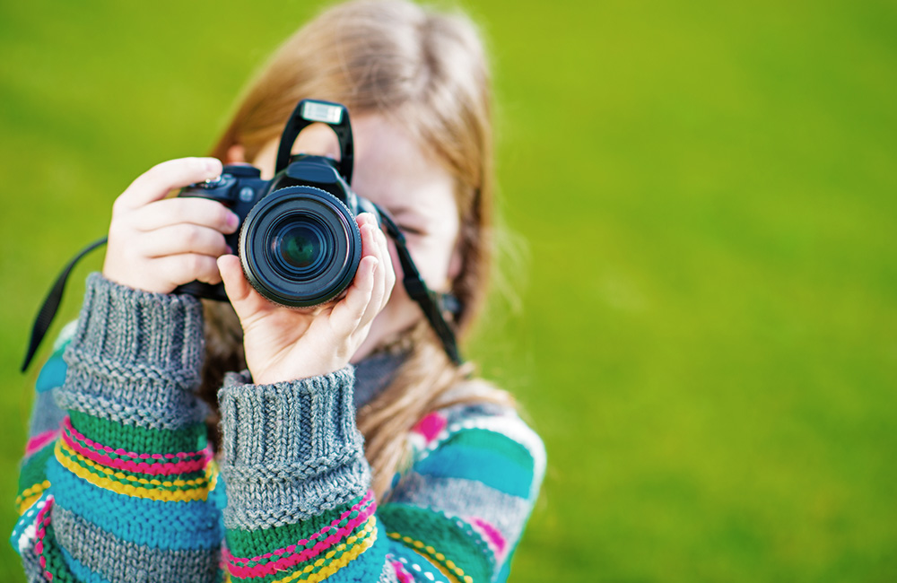 A young girl takes photos with her camera
