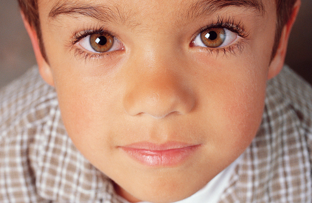 A cute young boy smiles at us