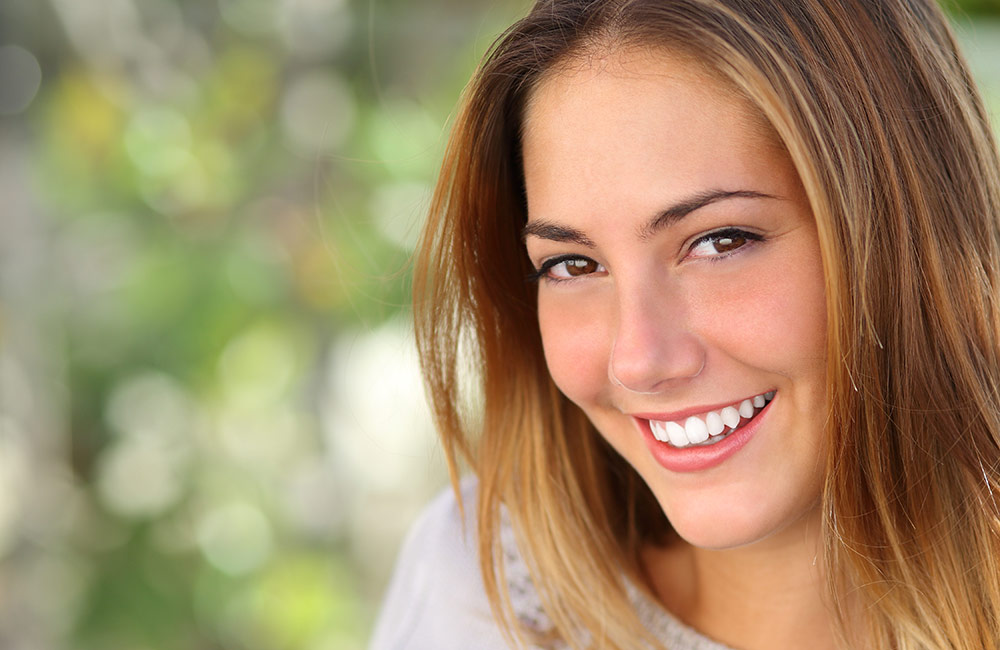 A young woman smiles at us