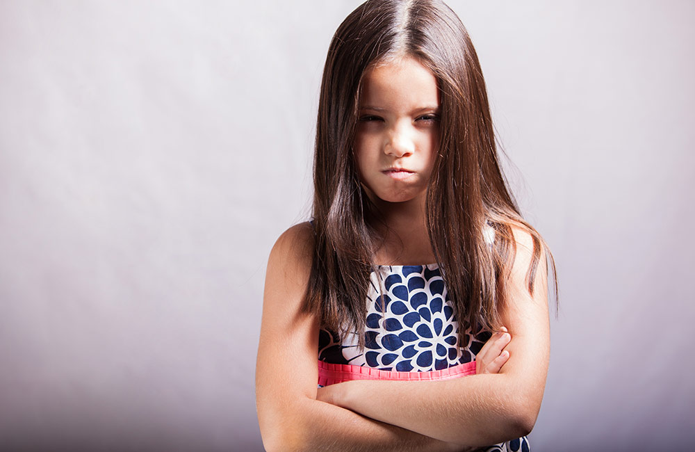 A young child looking angry and dejected