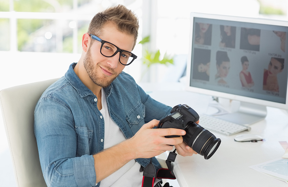 A male photographer holding a camera